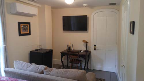 desk, mini-fridge, tv, arched door